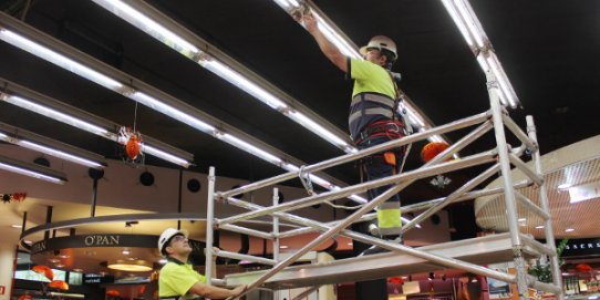 Els treballadors de la brigada municipal, col·locant els llums led al Mercat Municipal.