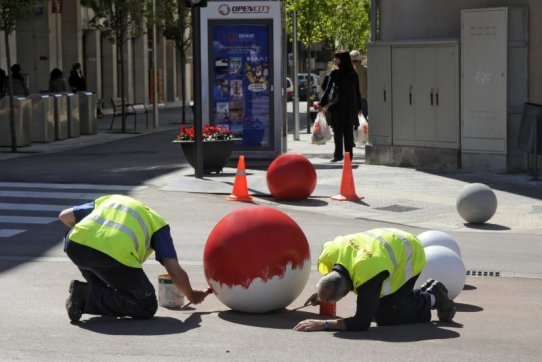 Els operaris de Via Pública pintant una de les boles