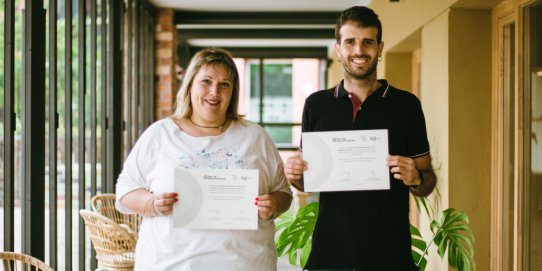 La regidora de Diversitat Funcional, Anna Margalef, i el treballador social de diversitat funcional de l'Ajuntament, Enric Moreno, amb els dos diplomes acreditatius.